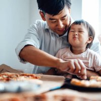 young father feeding food for his baby daughter at the table - junk food stock pictures, royalty-free photos & images