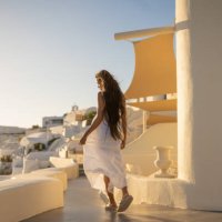 young female asian woman with white dress on a vacation in santorini, enjoying the view of the traditional architecture - travel stock pictures, royalty-free photos & images