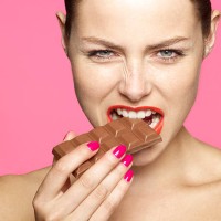 young female eating chocolate - junk food stock pictures, royalty-free photos & images