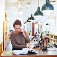 young female sales clerk talking on mobile phone while looking at file in home improvement store - home decoration stock pictures, royalty-free photos & images
