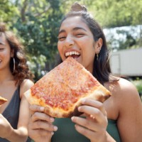 young females hanging out in city eating pizza - food stock pictures, royalty-free photos & images