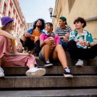 young friends talking sitting on a staircase outdoors - fashion stock pictures, royalty-free photos & images