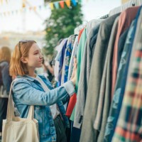 young girl choosing clothes in a second hand market in summer, zero waste concept - fashion stock pictures, royalty-free photos & images