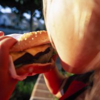 young girl eating a hamburger - junk food stock pictures, royalty-free photos & images