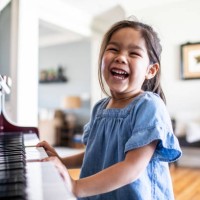 young girl playing piano at home - concert stock-fotos und bilder