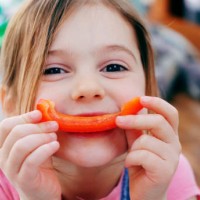 young girl smiling with pepper - food stock pictures, royalty-free photos & images