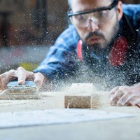 young handosme carpenter blowing off sawdust - home decoration stock pictures, royalty-free photos & images