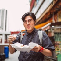 young handsome man enjoying hong kong local street food joyfully in street - food stock pictures, royalty-free photos & images