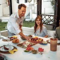 young handsome man serving food for his friends in his backyard - garden decoration photos et images de collection