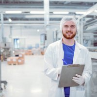 young handsome smiling scientist with clipboard posing in factory - food stock pictures, royalty-free photos & images