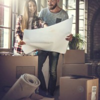 young happy couple looking at renovation plans at their new home. - home decoration stock pictures, royalty-free photos & images