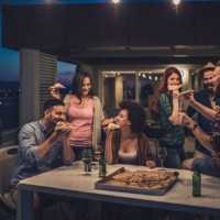 young happy people having a dinner party during the night on a terrace. - junk food stock pictures, royalty-free photos & images