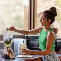 young hispanic woman chopping ingredients for healthy smoothie in kitchen - food stock pictures, royalty-free photos & images