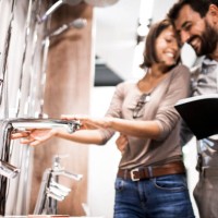 young husband and wife looking for a shower faucet in a specialized bathroom equipment store - home decoration stock pictures, royalty-free photos & images