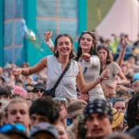 Young lady on the shoulders of a friends in crowd enjoys live music at Boomtown Fair Festival. Boomtown aka Boomtown Fair is a British music festival...