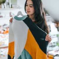 young latina woman choosing a sweater from her closet - fashion photos et images de collection