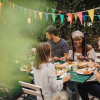 young male and female friends enjoying food at table during dinner party in backyard - garden decoration stock pictures, royalty-free photos & images