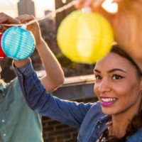 young man and woman hanging lights at roof party in london, uk - garden decoration stock pictures, royalty-free photos & images