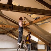 young man and woman mouting insulation on construction site - home decoration stock pictures, royalty-free photos & images
