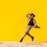 young man dancing in front of yellow wall, jumping mid air - fashion stock pictures, royalty-free photos & images