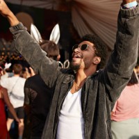young man dancing with arms raised by girlfriend - concert photos et images de collection