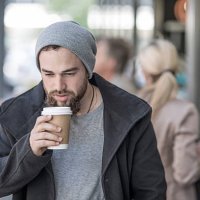 young man drinking takeaway coffee in the city - junk food stock pictures, royalty-free photos & images