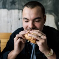 young man eating a burger - junk food stock pictures, royalty-free photos & images