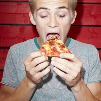 young man eating pizza - junk food stock pictures, royalty-free photos & images