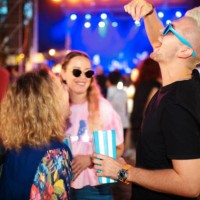 young man having fun eating popcorn on music festival, female friends laughing - concert stock pictures, royalty-free photos & images