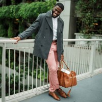 young man laughs, holding duffel bag outside airport - fashion stock pictures, royalty-free photos & images