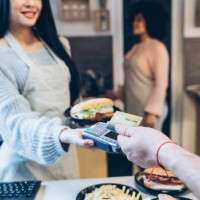 young man paying with credit card in fast food restaurant - junk food stock pictures, royalty-free photos & images