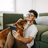 young man playing with his dog - home decoration stock pictures, royalty-free photos & images