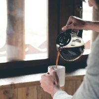 young man pouring coffee into cup at home - coffee stock pictures, royalty-free photos & images