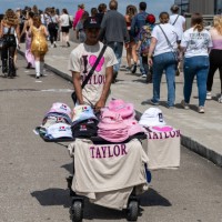 Young man sells t-shirts and hats as Fans make their way to Nissan Stadium ahead of artist Taylor Swift's second night of performance on May 6, 2023...