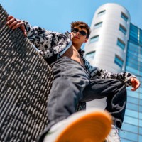 young man sitting on a concrete wall - fashion stock pictures, royalty-free photos & images