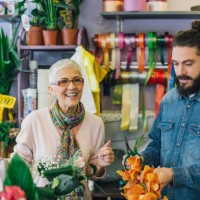 young man trimming flowers with a florist - garden decoration stock pictures, royalty-free photos & images