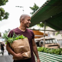 young man walking in a street market - food stock pictures, royalty-free photos & images