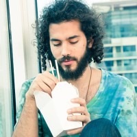 young man with chinese takeout - junk food stock pictures, royalty-free photos & images