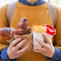 young man with croissant and coffee to go - junk food stock pictures, royalty-free photos & images