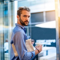 young man with newspaper and takeaway coffee - junk food stock pictures, royalty-free photos & images