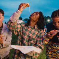 young men eating pizza at festival - junk food stock pictures, royalty-free photos & images