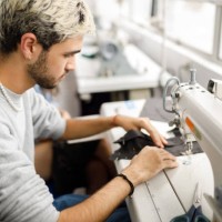 young men using a sewing machine - fashion stock pictures, royalty-free photos & images