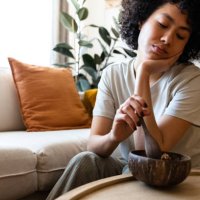 young multiracial woman eating breakfast feeling very bored and unmotivated. lack of appetite. copy space. - food stock pictures, royalty-free photos & images