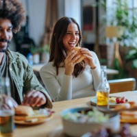young people enjoying burgers and beer at home party - junk food stock pictures, royalty-free photos & images