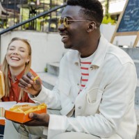 young people hang out and eat fast food on the street - junk food stock pictures, royalty-free photos & images