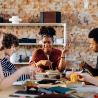 young people sitting together at table having lunch break - junk food stock pictures, royalty-free photos & images