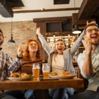 young people watching soccer game in pub cheering during goal - food stock pictures, royalty-free photos & images