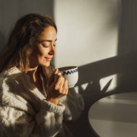 young pretty woman enjoying morning coffee at home. beautiful sun light in kitchen room. - coffee stock pictures, royalty-free photos & images