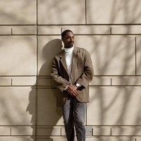 young professional standing confidently against a sunlit wall outdoors - fashion stock pictures, royalty-free photos & images