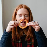 young red haired woman eating junk food - junk food fotografías e imágenes de stock